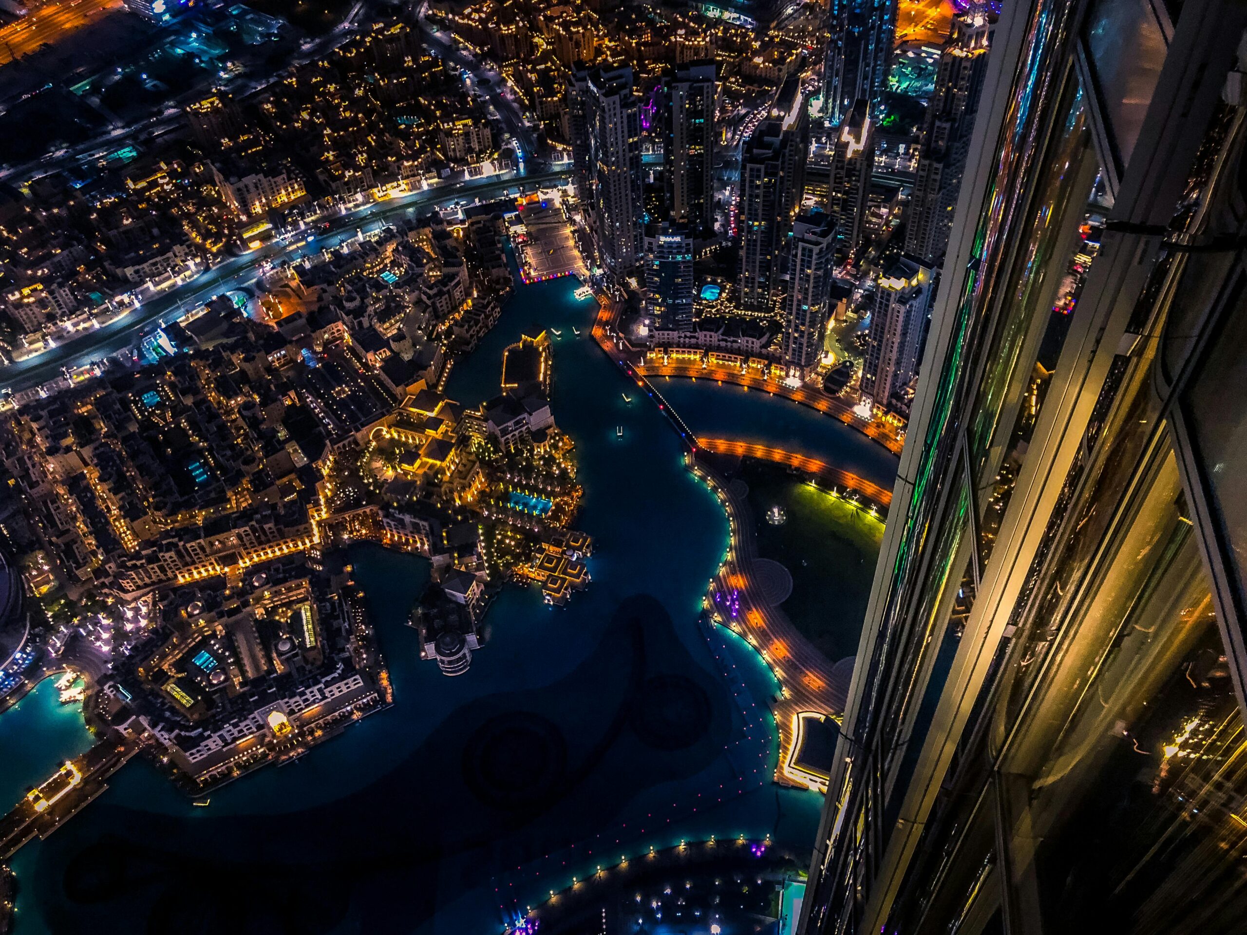Home Vibrant aerial cityscape of Dubai at night with illuminated skyscrapers and urban landscape.